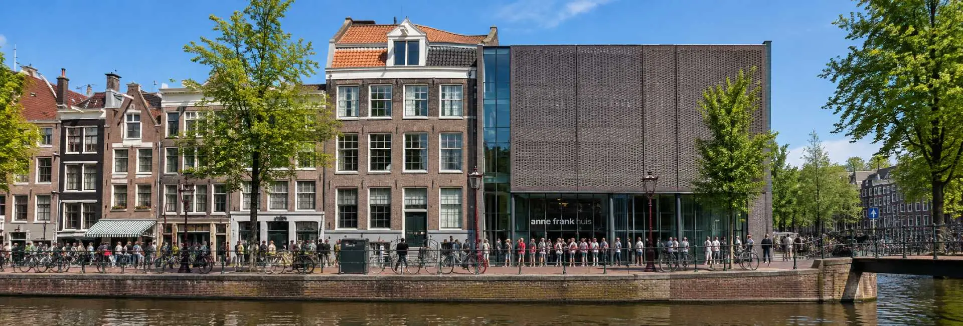 Anne Frank House museum beside Prinsengracht canal in Amsterdam on a bright sunny day