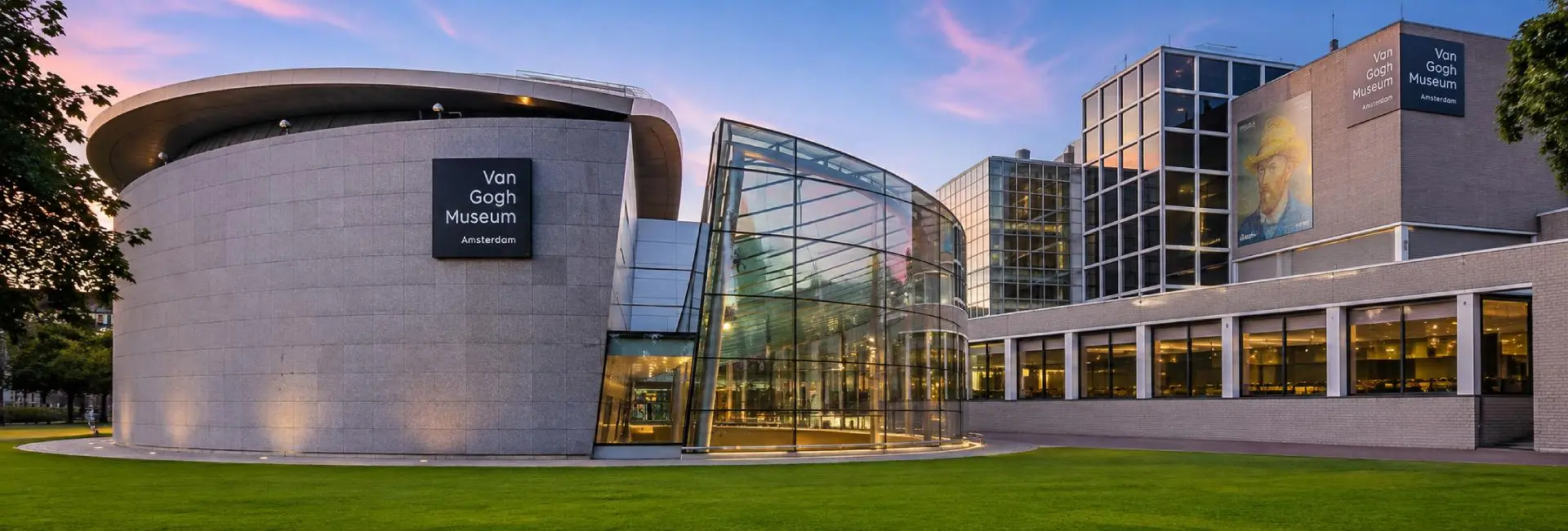 Panoramic exterior view of the Van Gogh Museum in Amsterdam with modern architecture at sunset.