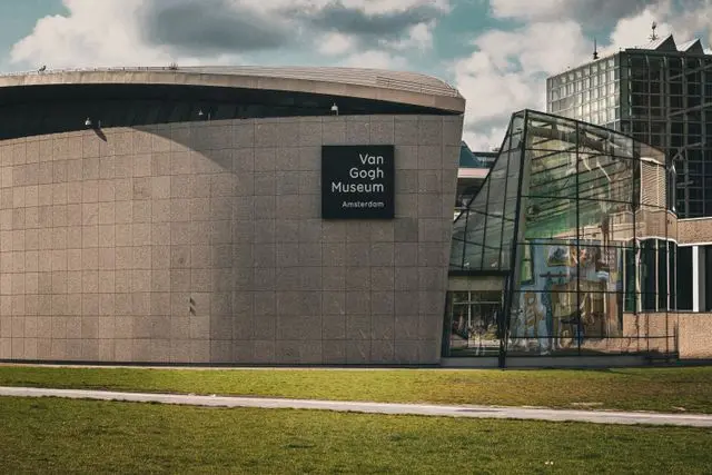 Front view of the Van Gogh Museum building in Amsterdam with its iconic modern glass entrance.