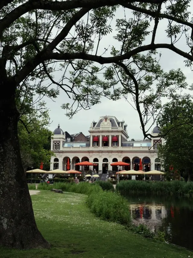 Vondelpark Pavilion overlooking a peaceful pond and landscaped gardens in Amsterdam.