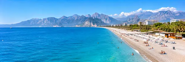 Konyaaltı Beach in Antalya, Türkiye, with turquoise waters and dramatic mountain views
