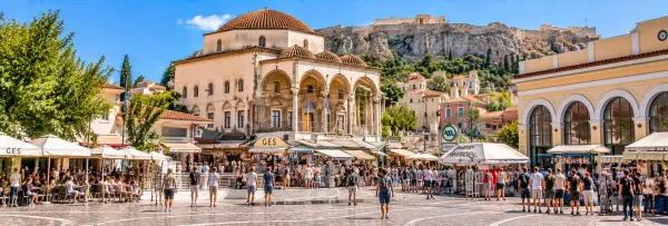 Monastiraki Square in Athens, Greece, with market stalls, historic buildings, and the Acropolis