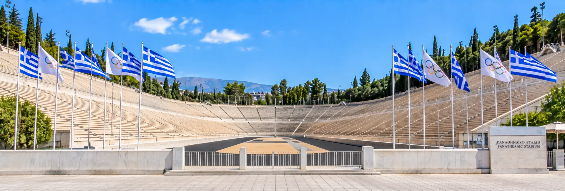 Panathenaic Stadium in Athens, Greece, with marble seating, Olympic flags, and surrounding hills