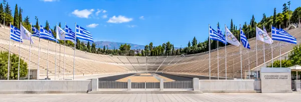 Panathenaic Stadium in Athens, Greece, with marble seating, Olympic flags, and surrounding hills