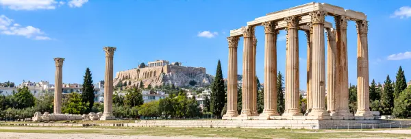 Temple of Olympian Zeus in Athens, Greece, with towering Corinthian columns and the Acropolis in the background