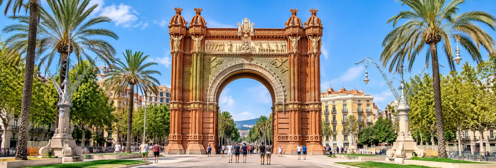 Arc de Triomf in Barcelona with palm trees and the Passeig de Lluís Companys promenade