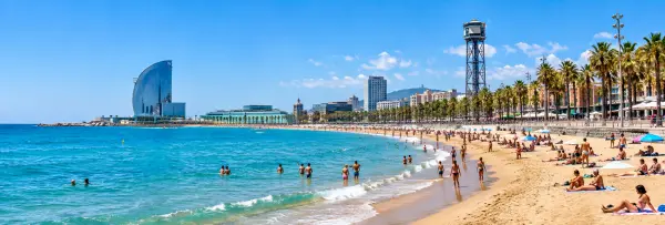 Barceloneta Beach with golden sand, Mediterranean waters and Barcelona waterfront skyline