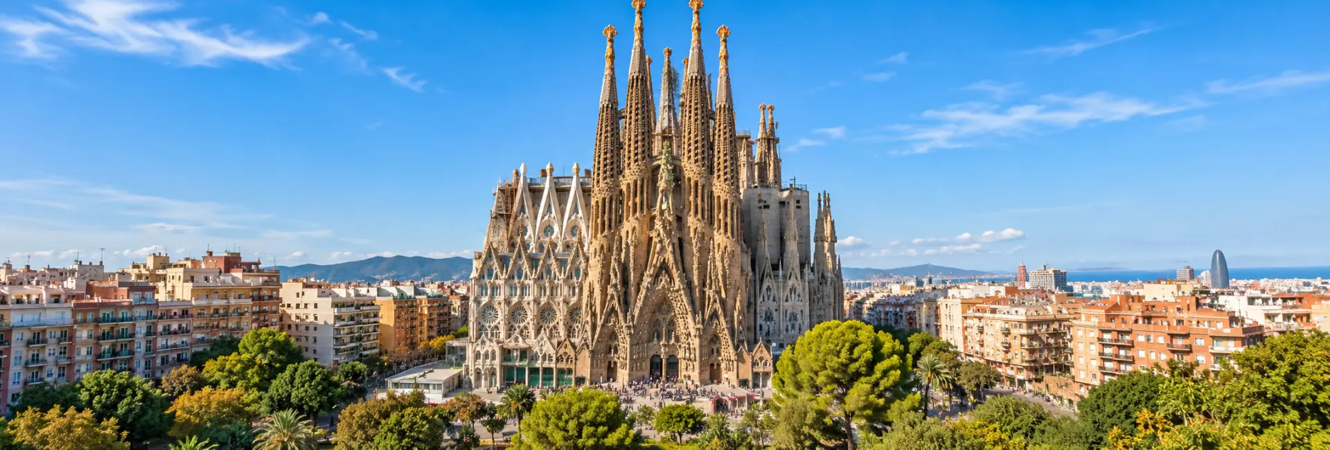 Sagrada Família in Barcelona, Spain, surrounded by the cityscape under a clear blue sky