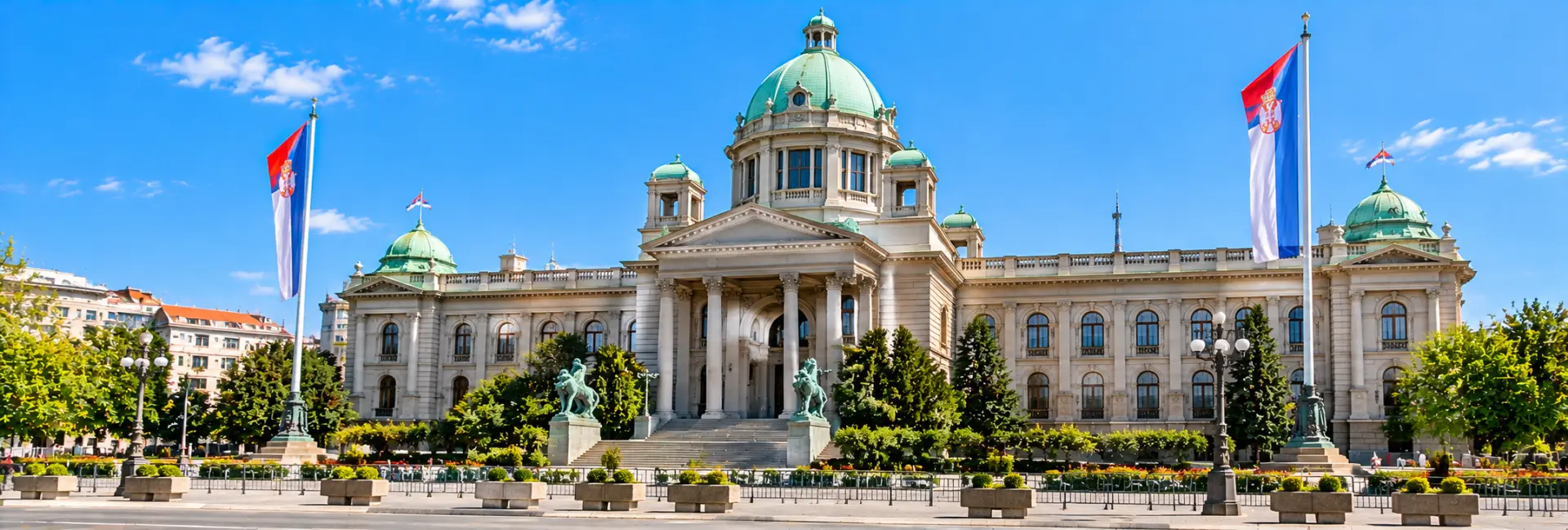 National Assembly of Serbia in Belgrade, featuring its grand neoclassical architecture, green domes and Serbian flags.