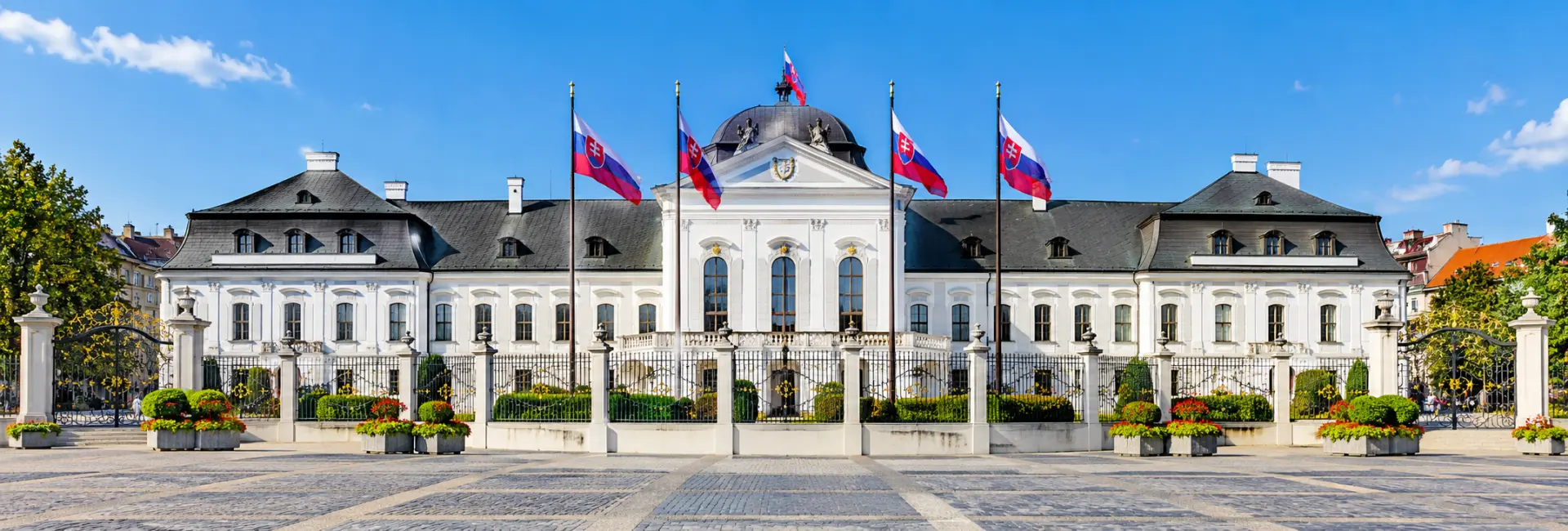 Grassalkovich Palace in Bratislava, Slovakia, featuring its elegant Baroque architecture and Slovak flags.