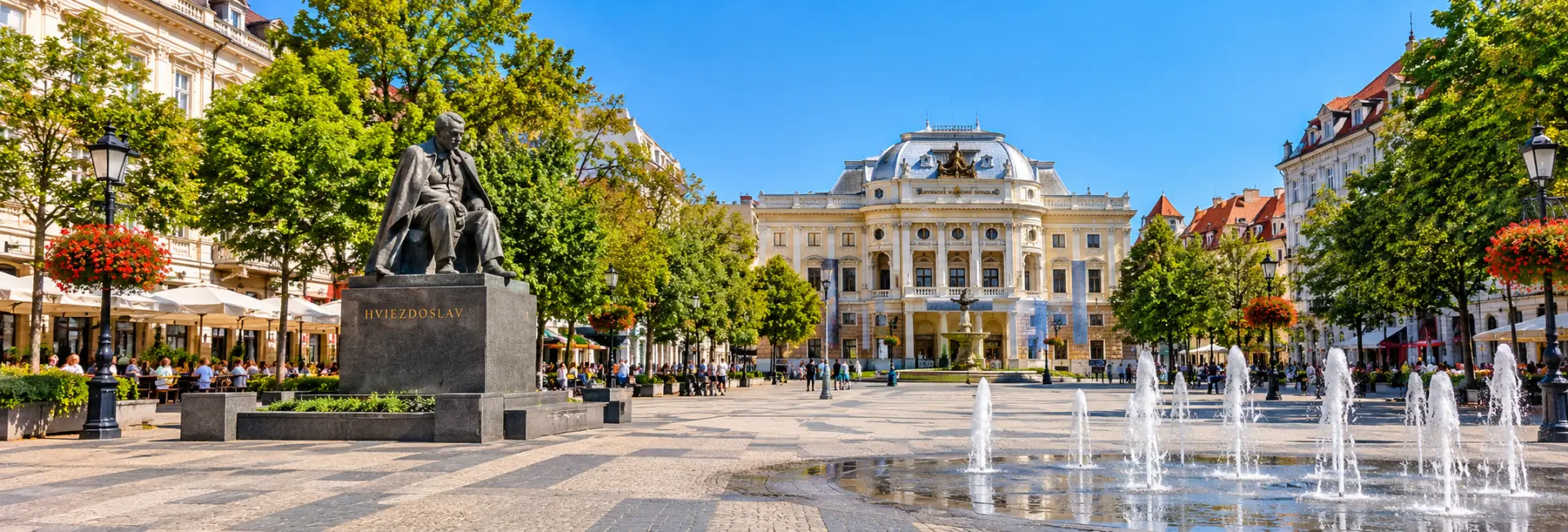 Hviezdoslav Square in Bratislava with its historic buildings, fountains, trees, and Hviezdoslav statue.