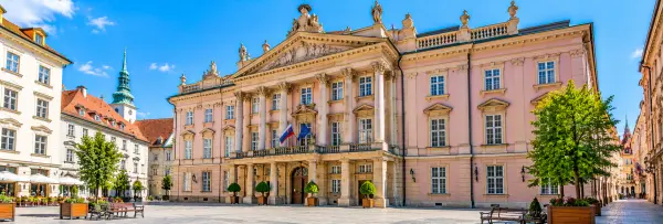 Primate’s Palace in Bratislava, Slovakia, featuring its elegant pink neoclassical facade and grand columns.