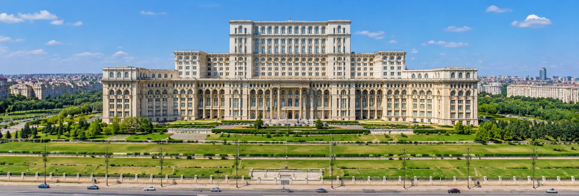 Panoramic daytime view of the Palace of the Parliament in Bucharest, Romania, showcasing its grand architecture.