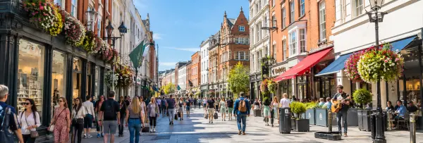 Grafton Street in Dublin with historic buildings, shops, pedestrians and lively street performers