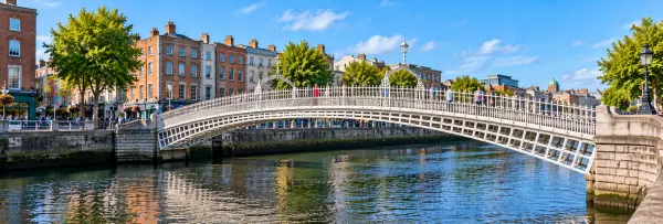 Ha’penny Bridge in Dublin spanning the River Liffey with historic buildings