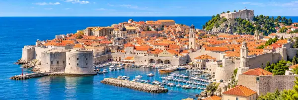 Dubrovnik Old Town in Croatia with historic city walls, red rooftops and the Adriatic Sea.