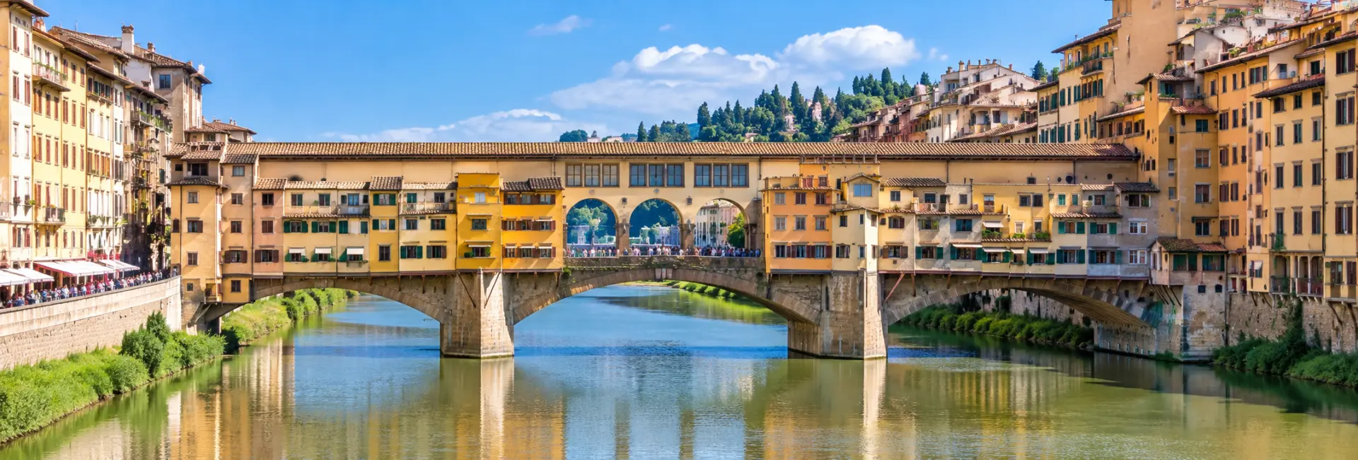 Ponte Vecchio in Florence, Italy, spanning the Arno River with colorful historic buildings