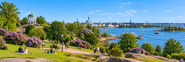 Kaivopuisto Park in Helsinki, Finland, with green lawns, flowering gardens, and scenic sea views.