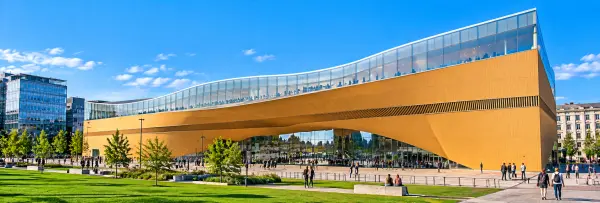 Oodi Central Library in Helsinki, Finland, featuring its curved wooden façade and modern glass architecture.