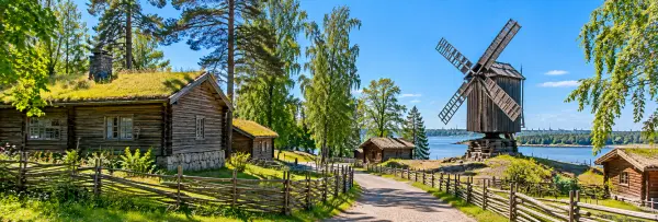 Seurasaari Open-Air Museum in Helsinki, featuring traditional wooden cottages, a windmill, and scenic waterfront.