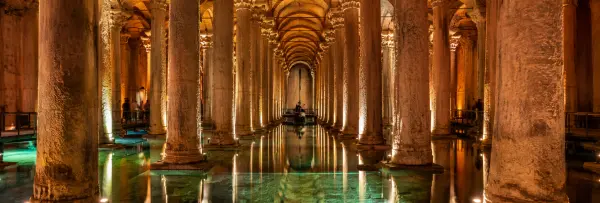 Basilica Cistern in Istanbul with illuminated ancient columns reflected in underground water.