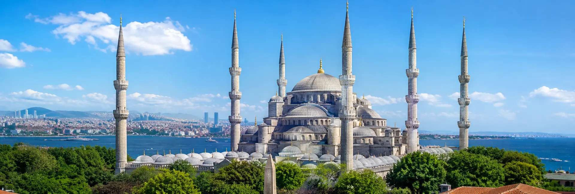 Blue Mosque (Sultan Ahmed Mosque) in Istanbul with six minarets, domes, and a blue sky.
