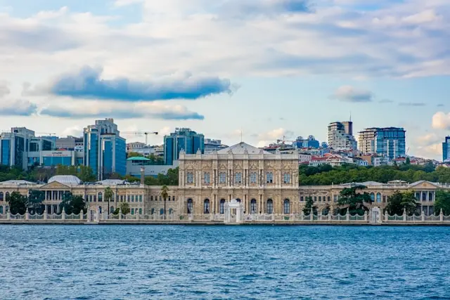 Dolmabahçe Palace viewed across the Bosphorus, with Istanbul buildings rising behind it.