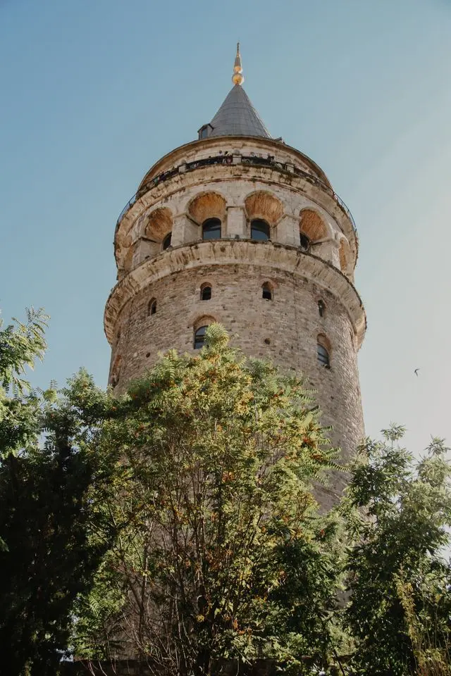 Close-up view of Galata Tower’s stone facade, arched windows, and conical roof.