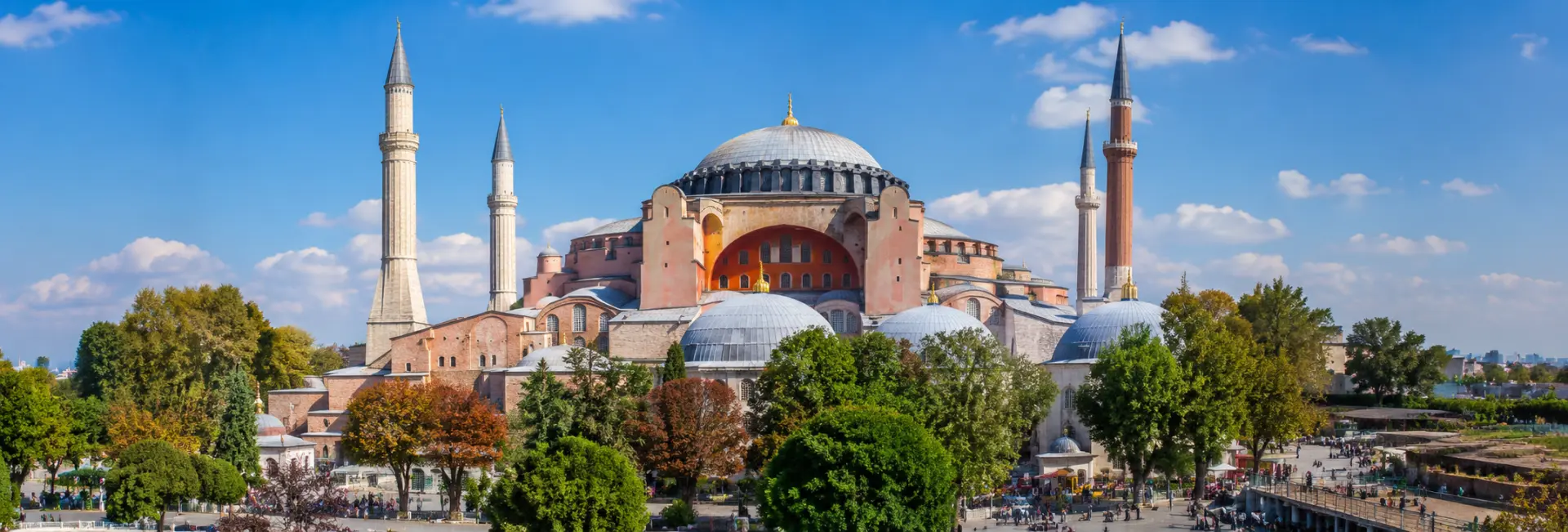 Hagia Sophia in Istanbul with its grand dome and four minarets under a clear blue sky.