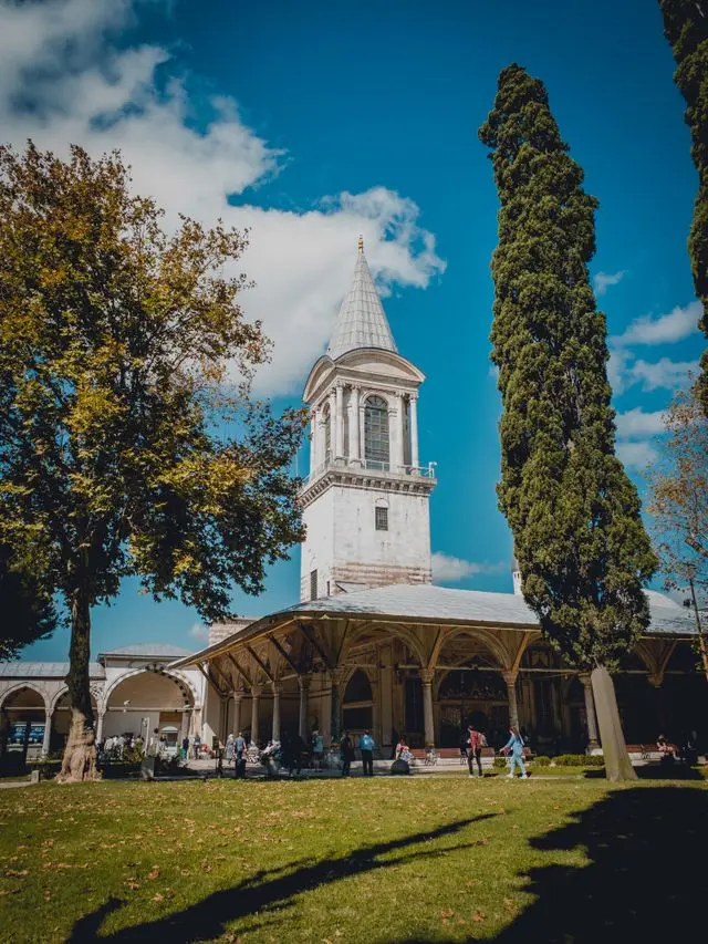 Topkapi Palace courtyard with its distinctive tower, trees, and historic Ottoman architecture.
