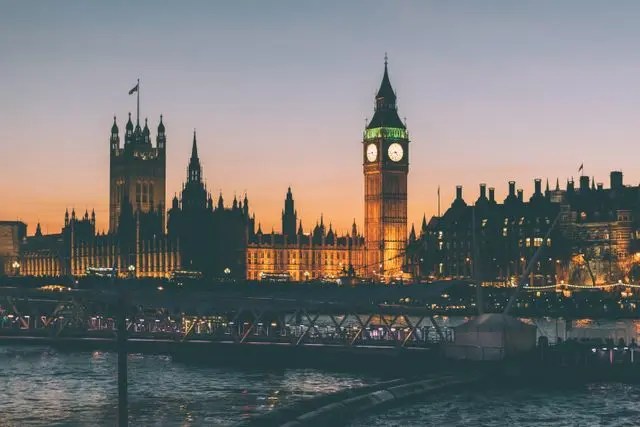 Big Ben and Palace of Westminster illuminated at sunset beside the River Thames