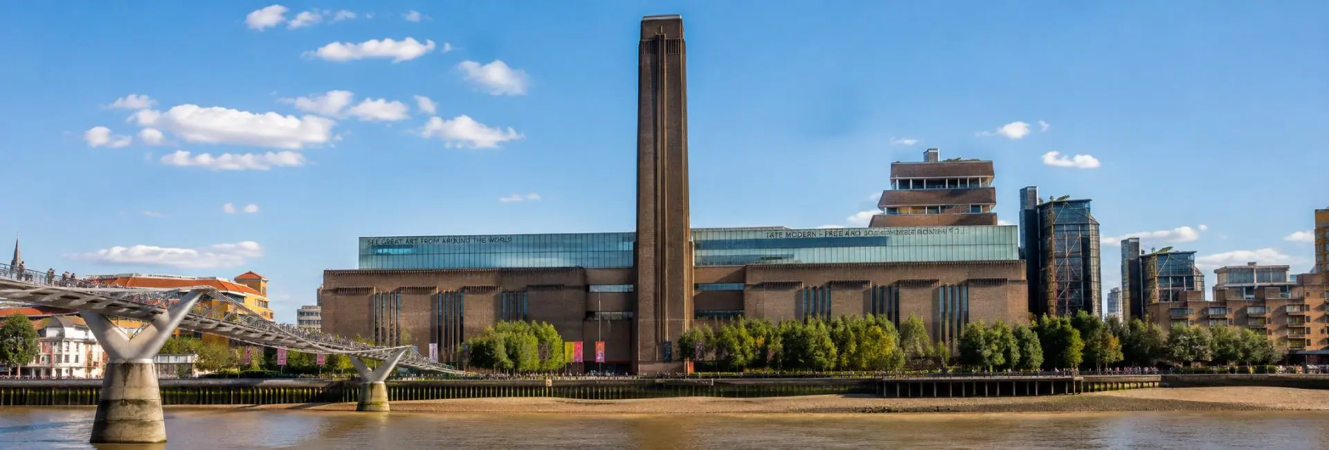 Tate Modern beside the River Thames with the Millennium Bridge and its iconic brick chimney
