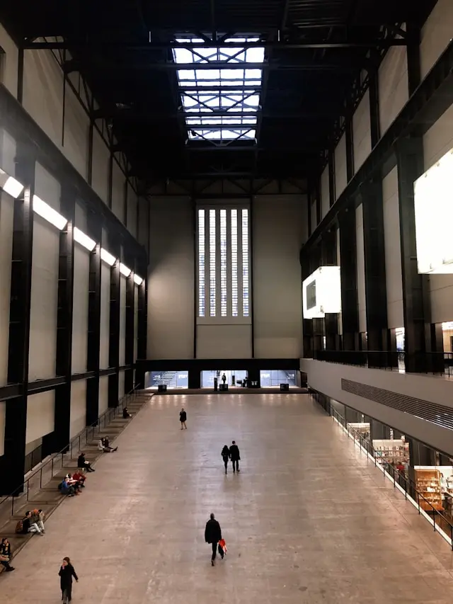 Tate Modern Turbine Hall in London with visitors walking through the vast industrial interior
