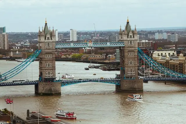 Tower Bridge over the River Thames in London, with boats and the city skyline.