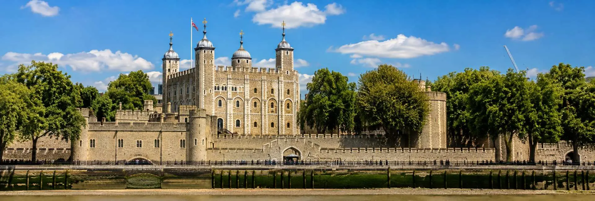 Tower of London and the White Tower viewed from the River Thames on a bright sunny day.
