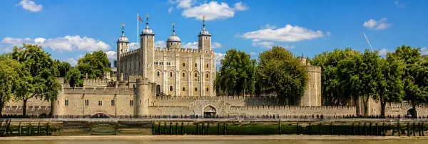 Tower of London and the White Tower viewed from the River Thames on a bright sunny day.