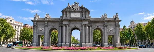 Puerta de Alcalá in Madrid with its weathered grey stone façade and ornate sculptures