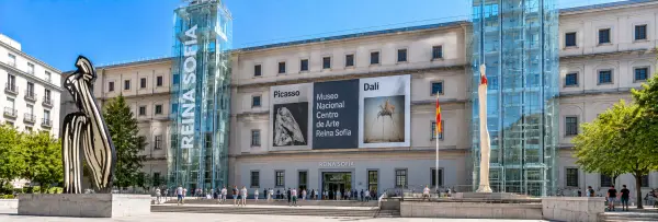 Reina Sofía Museum in Madrid with glass elevators, sculptures, and a Spanish flag