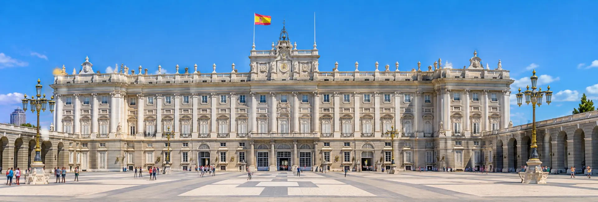 Royal Palace of Madrid with its grand façade and expansive courtyard under a blue sky