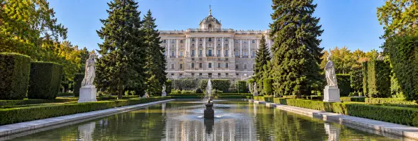 Sabatini Gardens in Madrid with manicured hedges, statues, fountain, and Royal Palace