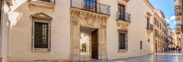 Museo Carmen Thyssen Málaga exterior with a carved stone doorway and iron balconies.