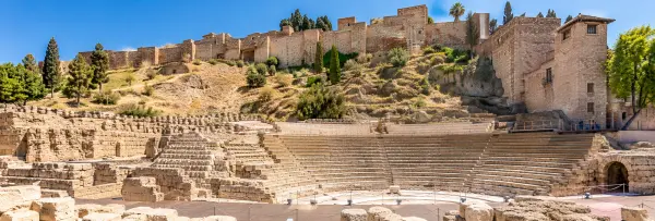 Roman Theatre of Málaga with ancient stone seating beneath the Alcazaba walls.