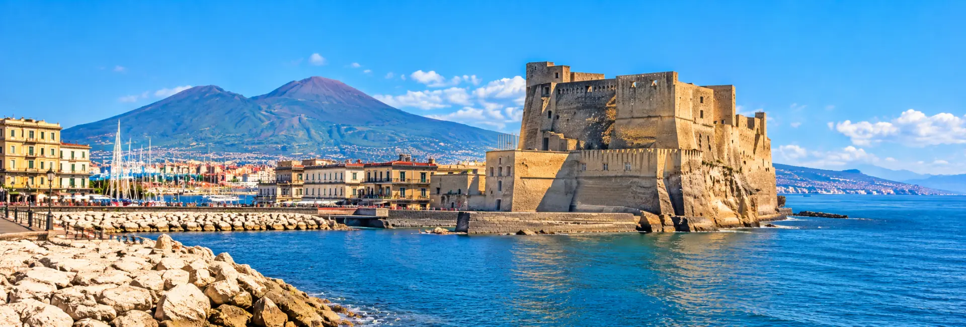 Castel dell’Ovo fortress on the Naples waterfront with Mount Vesuvius in the background