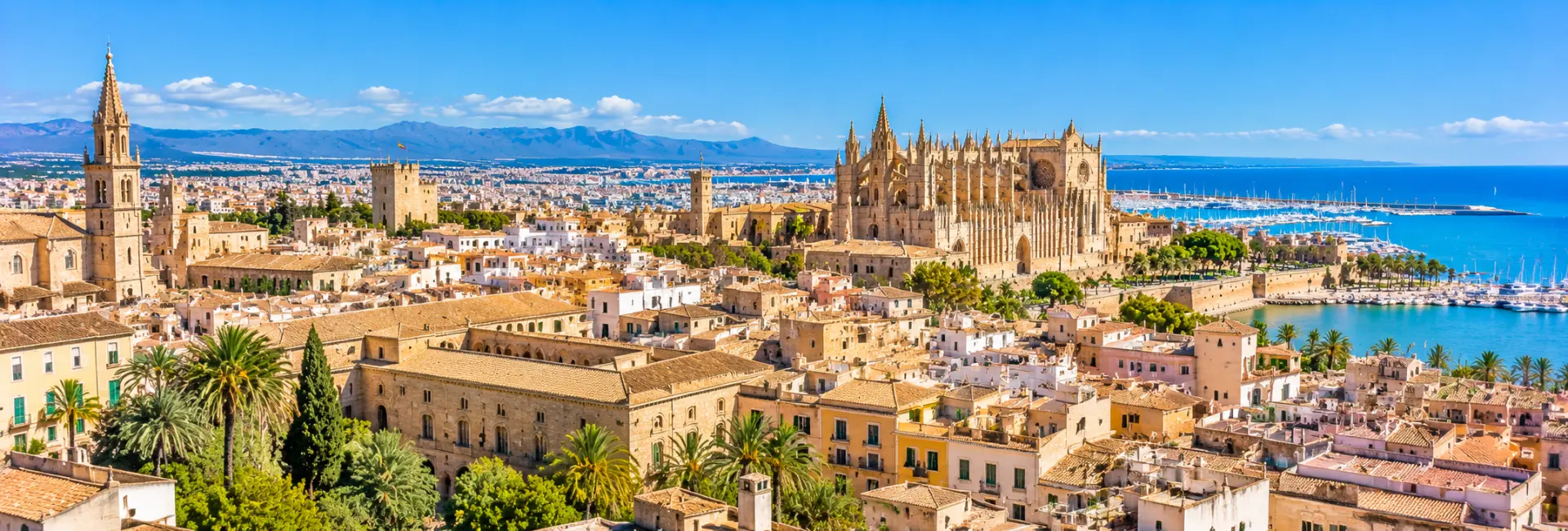 Panoramic view of Palma Old Town with historic buildings, Palma Cathedral and the Mediterranean Sea in Mallorca.