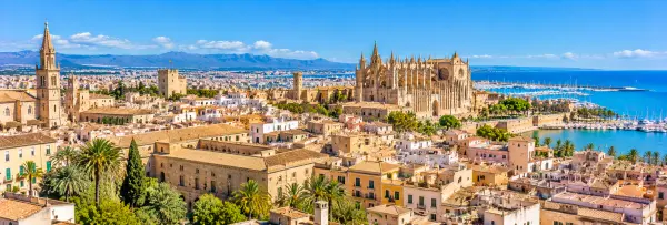 Panoramic view of Palma Old Town with historic buildings, Palma Cathedral and the Mediterranean Sea in Mallorca.