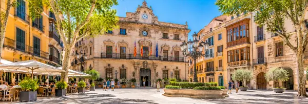 Plaza de Cort in Palma de Mallorca, featuring the historic Town Hall, elegant architecture and outdoor cafés.