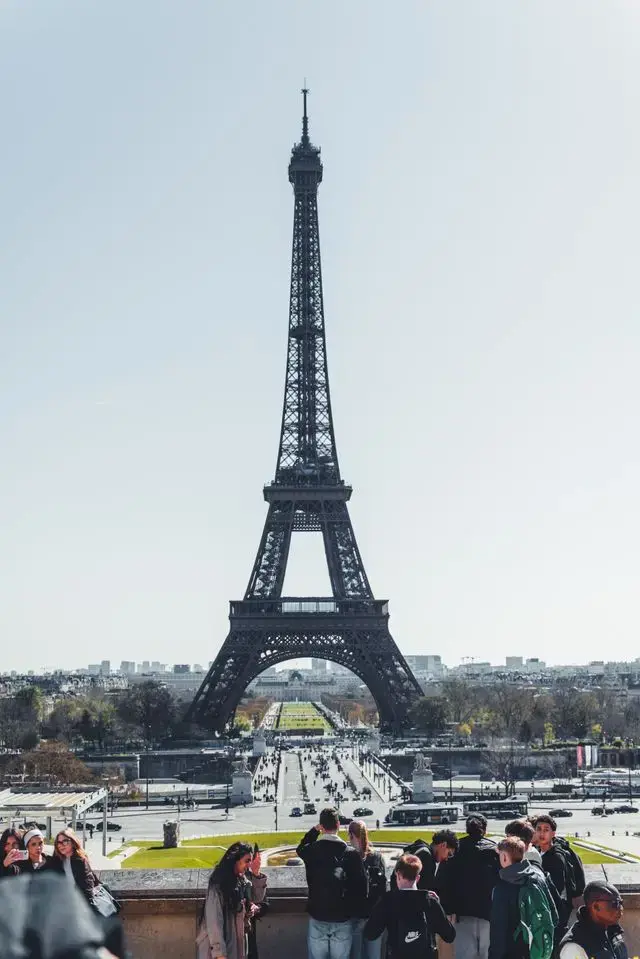 The Eiffel Tower in Paris viewed from the Trocadéro Gardens, with visitors enjoying the iconic landmark on a clear day.