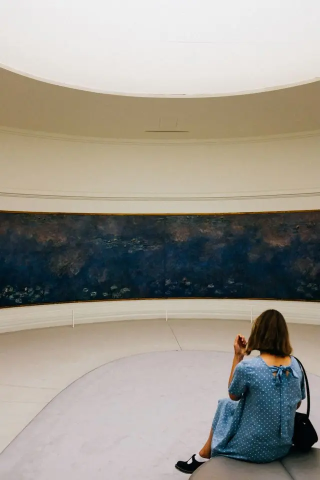 Visitor viewing Claude Monet’s Water Lilies at Musée de l'Orangerie in Paris