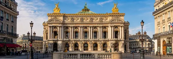 Palais Garnier opera house in Paris with its ornate Beaux-Arts architecture under a clear blue sky.