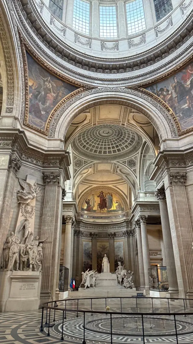 Interior of the Panthéon featuring ornate arches, murals, sculptures and a domed ceiling